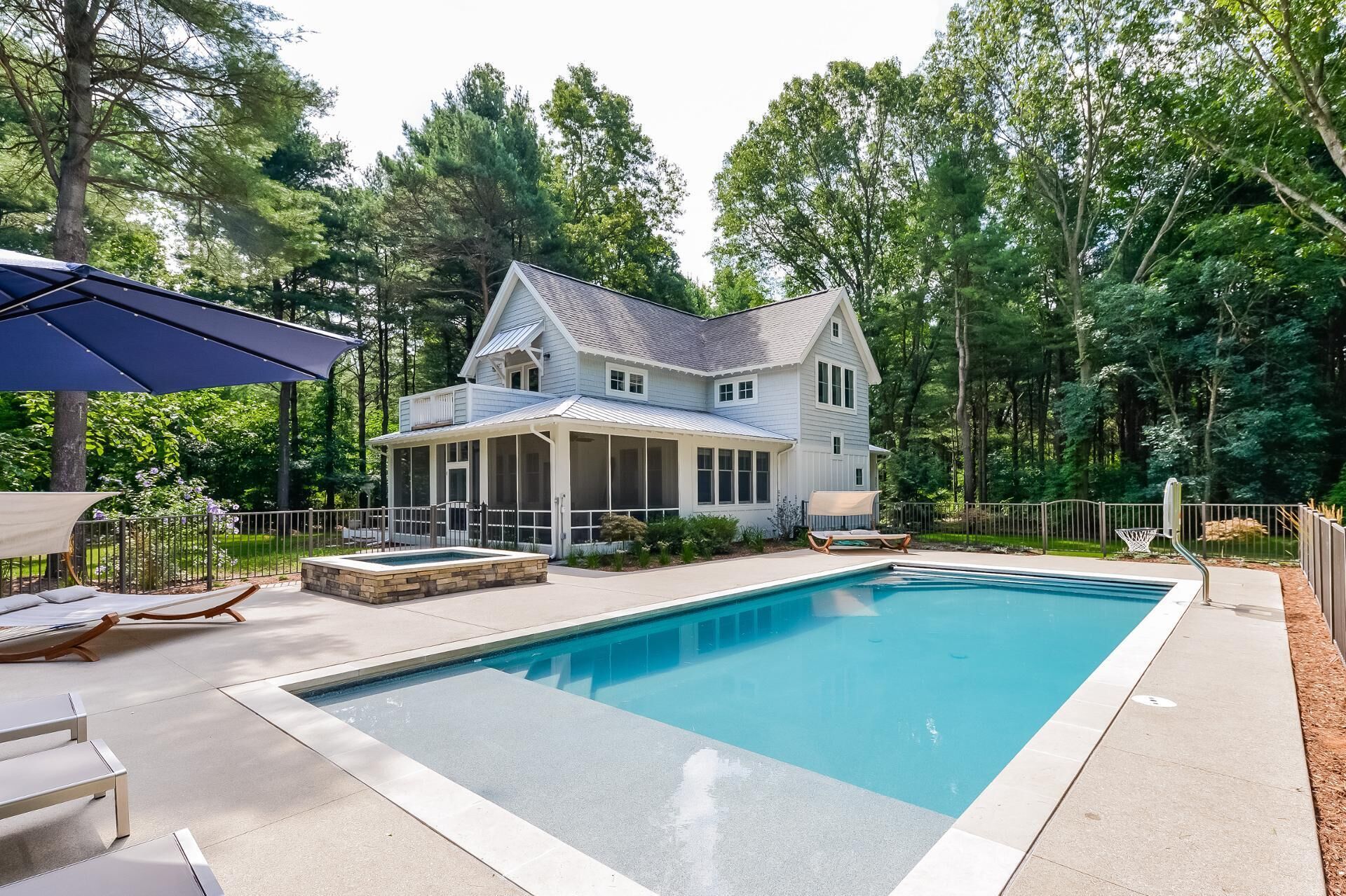 A two-story house with a screened porch and a swimming pool.