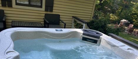A hot tub with a blue lid, a control panel, and a window.