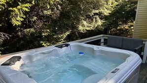 Un jacuzzi orné du logo Bullfrog, entouré d’arbres.