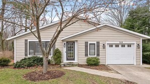 Une maison de plain-pied avec un garage, portant le numéro 568, et un jardin bien entretenu à l’avant, avec un arbre et des arbustes.