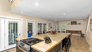 A spacious kitchen with a large island, built-in oven, and a gas stove.