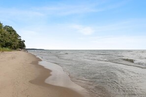 Une plage avec un rivage sablonneux et des vagues douces.