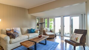 Amplia sala de estar con sofá, mesa de centro y sillón. Hay un telescopio y un cuenco sobre la mesa de centro.