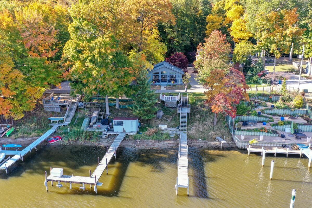 A lakeside property with a dock, a small house, and a garden area.