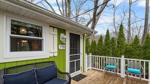 A green house with a porch, a number 719 sign, and a white fence. - "cozy Cottages" Green Cottage Hot Tub-town! (Saugatuck)