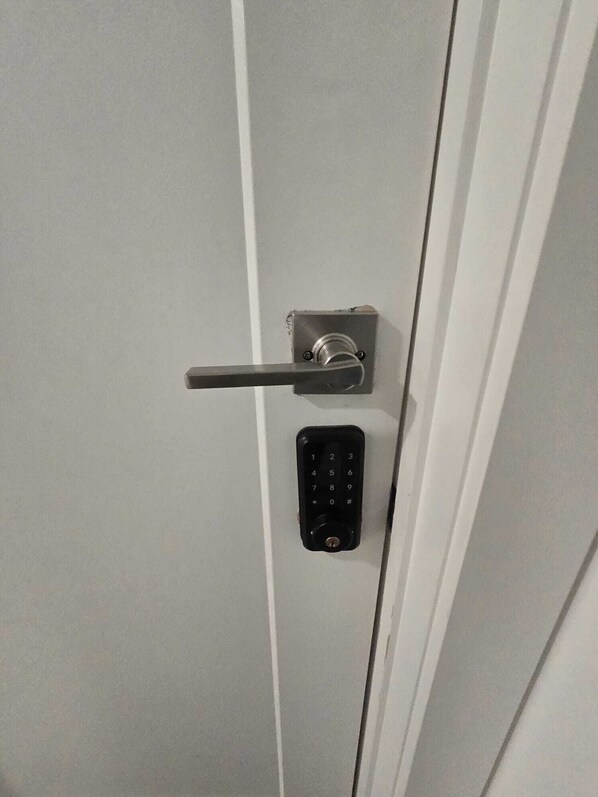 Una puerta con cerradura de llave y teclado numérico.
