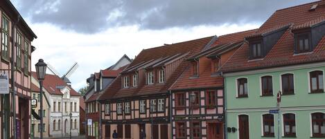 A street lined with traditional half-timbered houses, a clear sky, and a few pedestrians.