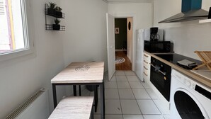 A compact kitchen with a washing machine, a microwave, and a coffee maker. - Refined Apartment With Courtyard in La Mans (Le Mans)