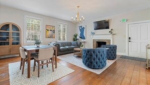 A living room with a fireplace, a dining area, and a sofa. - Downtown Huntsville Gem, 2BR Walk to the Square! (Huntsville)