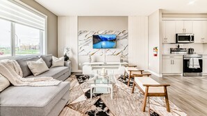 A modern living room with a sofa, coffee table, and TV.