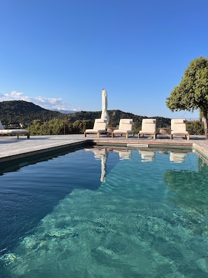 A clear swimming pool with lounge chairs and a view of a mountain range. - Deluxe 6 bed-6 bath villa, heated pool, view, quiet, AC, close to beaches (Porto-Vecchio)