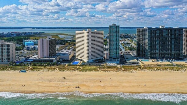 Eine Küstenstadt mit Hochhäusern, einem Sandstrand und Blick auf den Ozean.