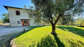 A stone building with a tree in front.