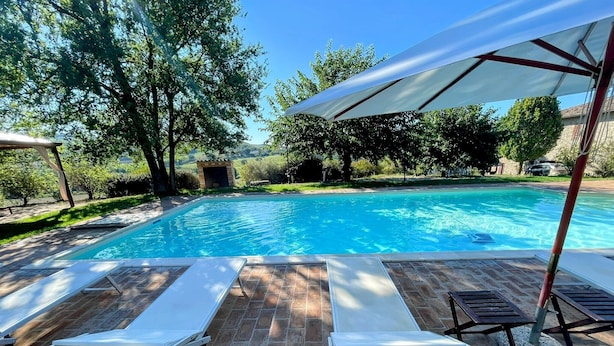 A swimming pool with two sun loungers and a covered area. - Detached Villa With Games Room, Pool, and Panoramic Views in San Damiano (Todi)