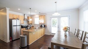 A modern kitchen with wooden cabinets, stainless steel appliances, and a central island. - Walk to Carter Finley, Minutes to SAS, Downtown (Raleigh)