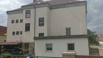 Un bâtiment à deux étages, doté de nombreuses fenêtres et d’une antenne parabolique.