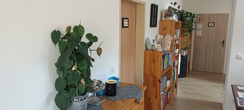 A hallway with a bookshelf, a potted plant, and a door labeled "BURROW PRIVATE."