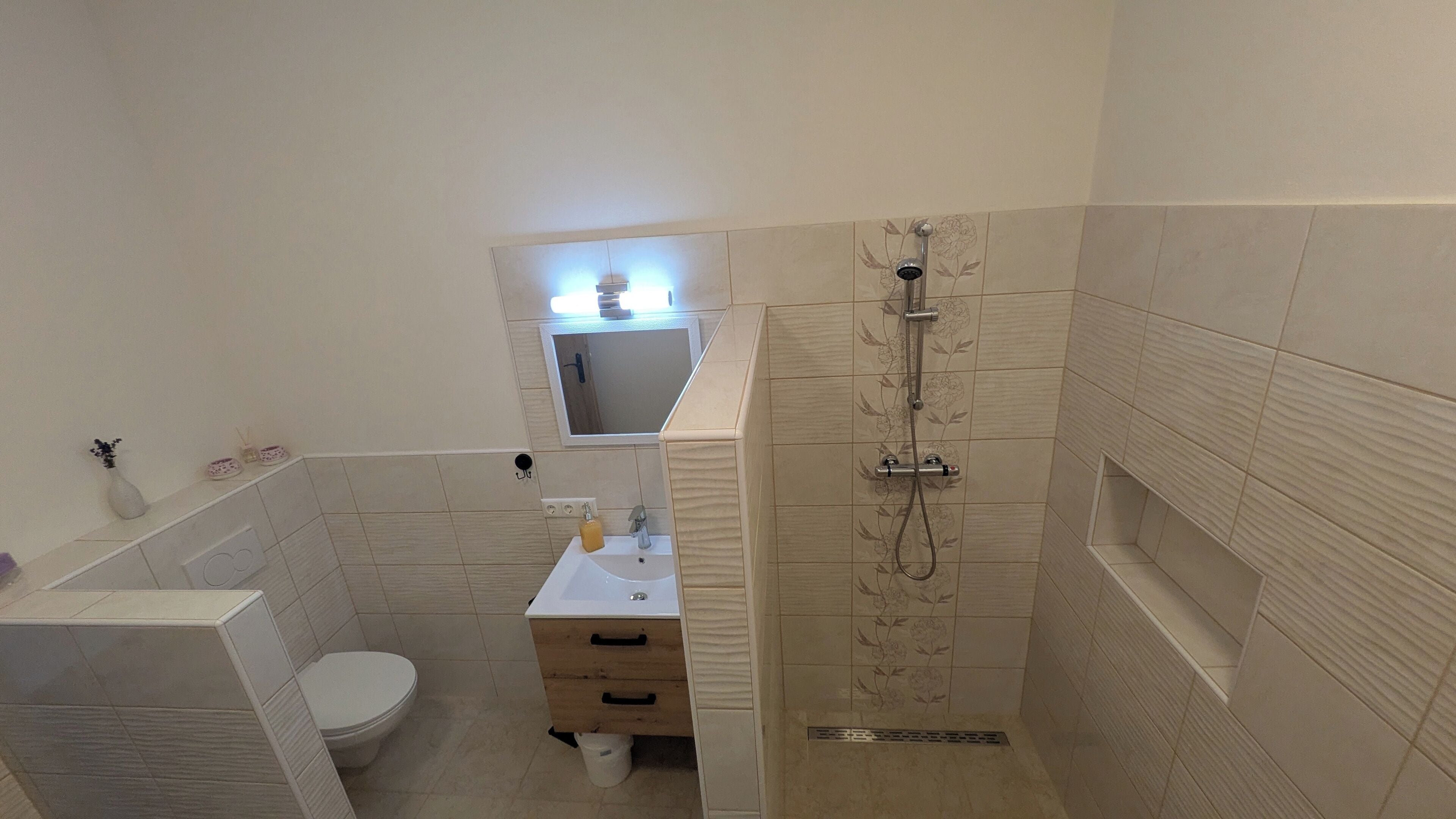 A bathroom with a toilet, sink, and shower.