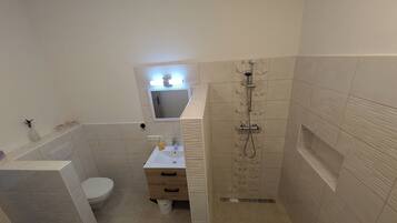 A bathroom with a toilet, sink, and shower.