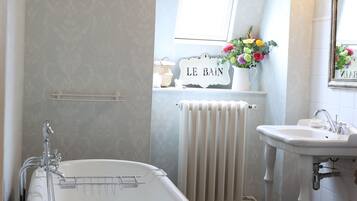 Un bany amb banyera independent, un lavabo i un vàter.