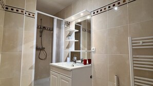 Un baño moderno con ducha, lavabo e inodoro.