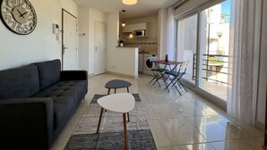 Una sala moderna con un sofá, una mesita y un reloj en la pared.