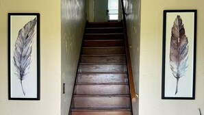 A wooden staircase with two framed feather paintings on either side. - Charming 3-bedroom farmhouse with AC, WiFi in quaint Austinburg (Austinburg)