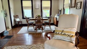 A dining area with a round table, wooden chairs, and a rug. - Charming 3-bedroom farmhouse with AC, WiFi in quaint Austinburg (Austinburg)