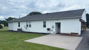 A single-story house with a front porch, a garage, and a small attached shed. - Charming 3-bedroom Country Porch Home with AC, WiFi in Welcoming Town of Dayton (Dayton)