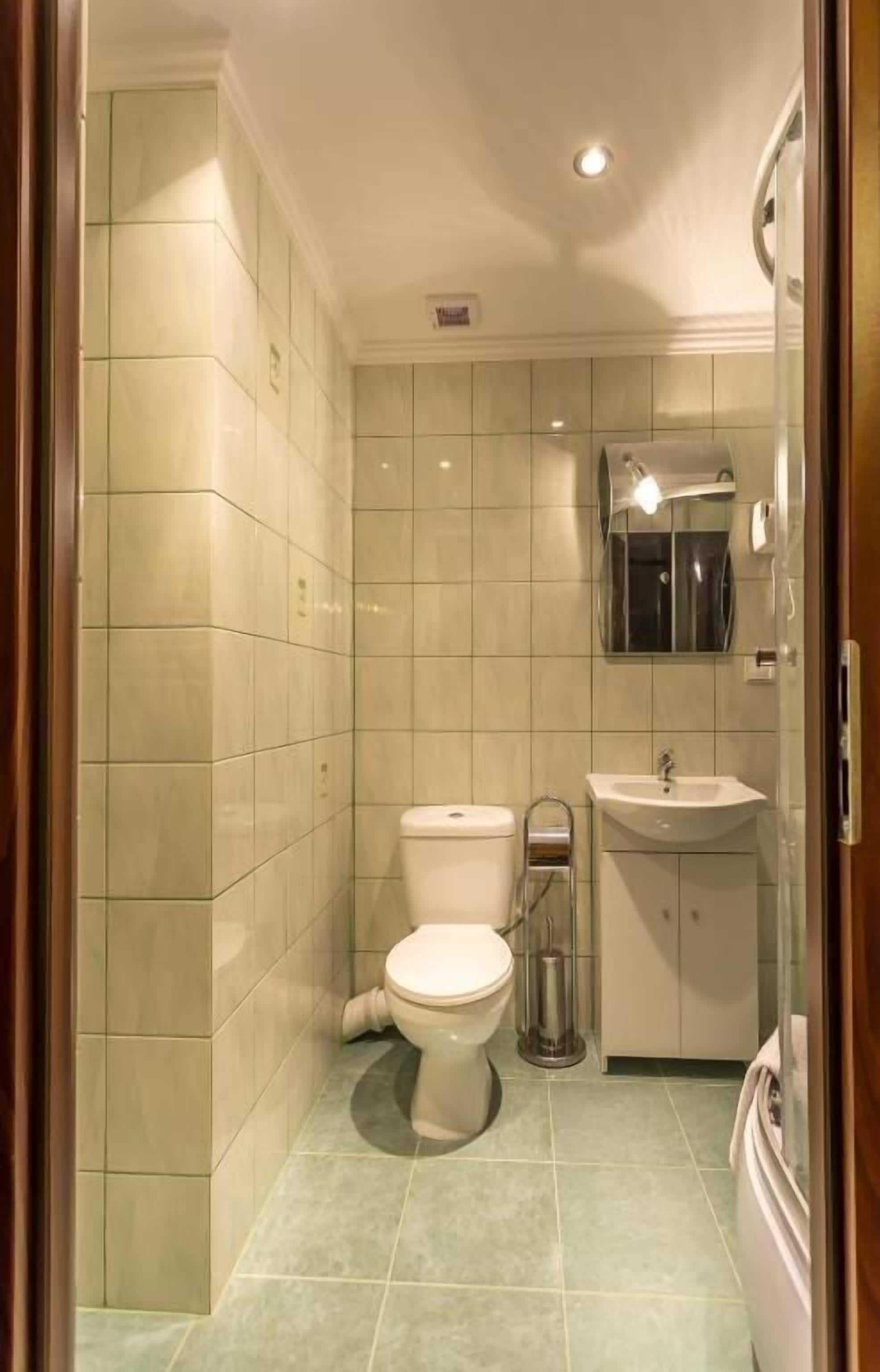 Een badkamer met toilet, wastafel en douche.