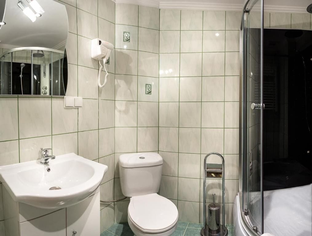 A bathroom with a sink, toilet, and glass shower enclosure.