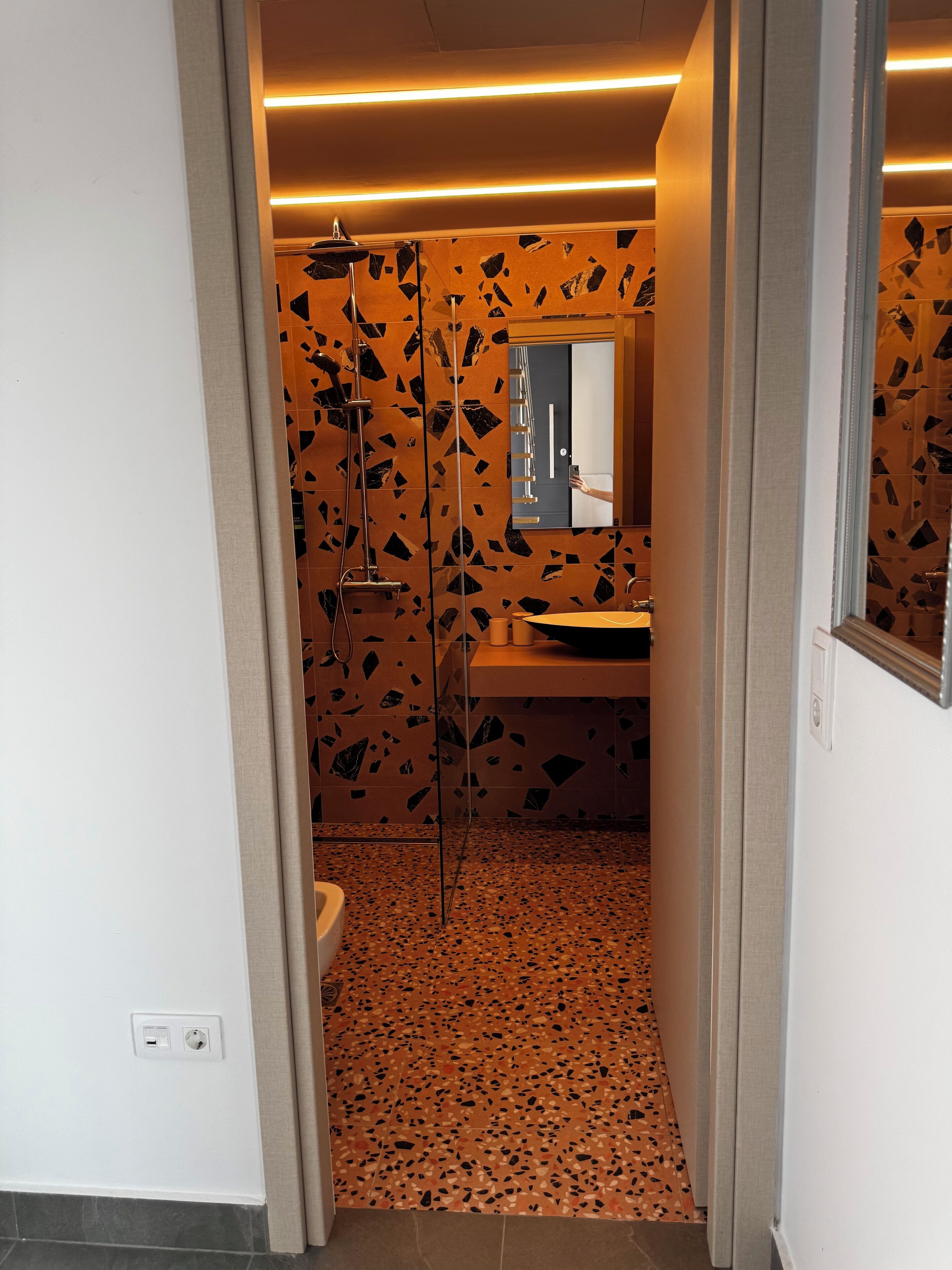 A modern bathroom with a shower, sink, and a mirror.