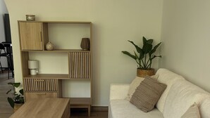 Ein modernes Wohnzimmer mit einer Couch, einem Couchtisch und einer Holzkommode mit Regalen.