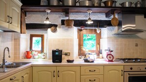 A kitchen with wooden cabinets, a sink, a stove, and hanging lights. - Podere Monte, panoramic terrace on the Apennines with walks and barbecues. (Gaggio Montano)