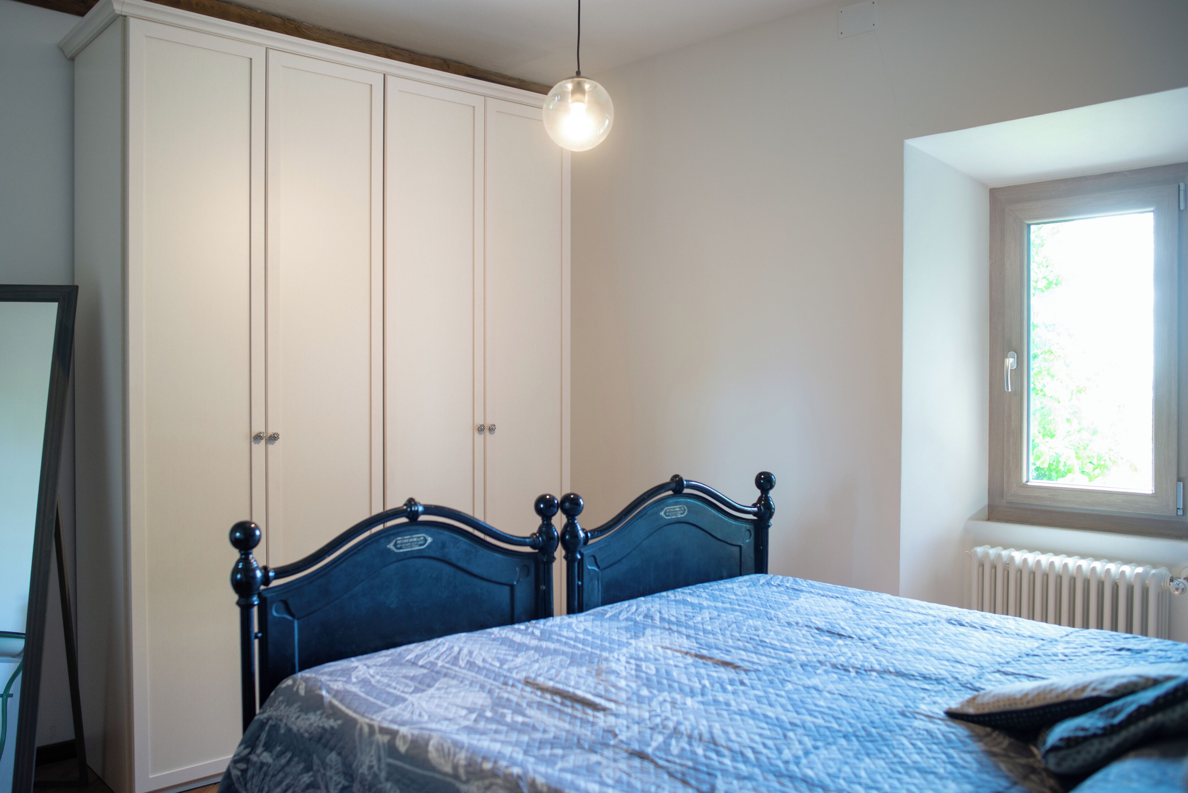 Ein Schlafzimmer mit Bett, Kleiderschrank und Fenster.