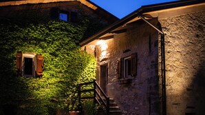A stone building with ivy-covered walls and a wooden staircase leading to a door. - Podere Monte, panoramic terrace on the Apennines with walks and barbecues. (Gaggio Montano)