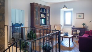 A spacious living room with a wooden cabinet, a red sofa, and a dining table. - Podere Monte, panoramic terrace on the Apennines with walks and barbecues. (Gaggio Montano)