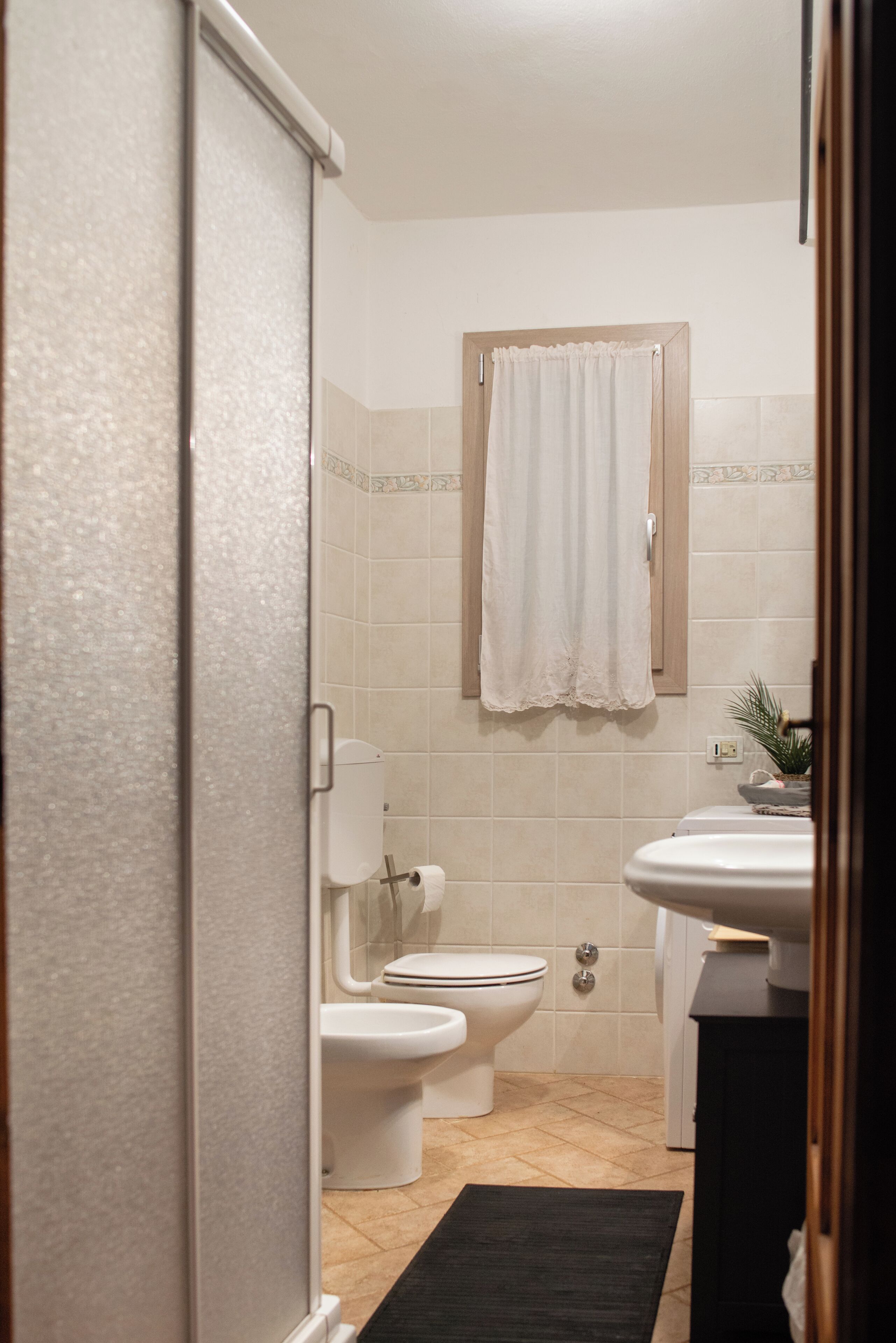 Une salle de bain comprenant des toilettes, un lavabo et un espace douche.