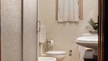 Une salle de bain comprenant des toilettes, un lavabo et un espace douche.