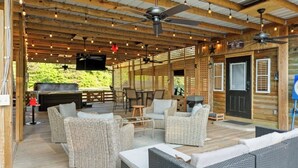 Una terrazza esterna con mobili in vimini, ventilatori a soffitto e una zona barbecue.
