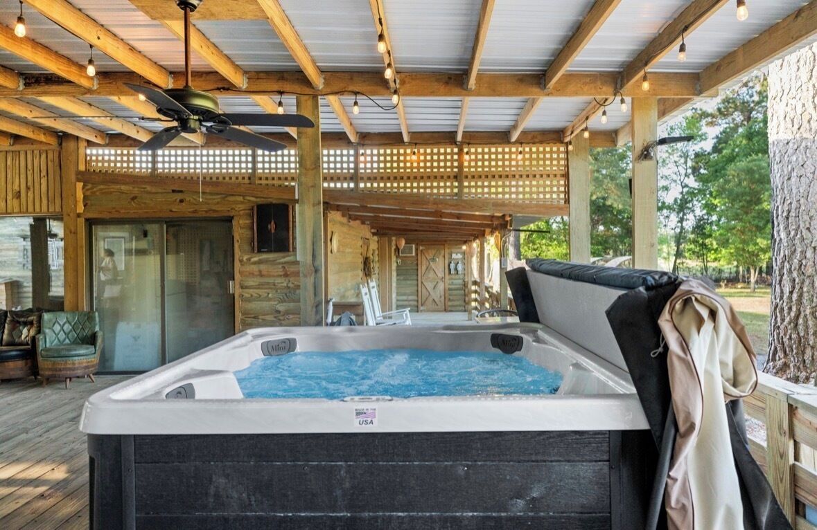 A hot tub in a covered outdoor area with wooden beams and a lattice ceiling.