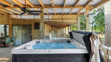A hot tub in a covered outdoor area with wooden beams and a lattice ceiling.