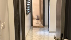 A hallway with a wooden door frame, a small table, and a rug on the floor. - Luxury apartment with lake view in Dakar (Dakar)