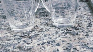 Twee glazen bekers op een granieten aanrecht.