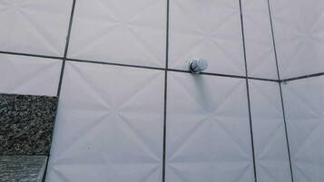 Un espacio de ducha con un estampado geométrico de azulejos y un cabezal de ducha de mano.