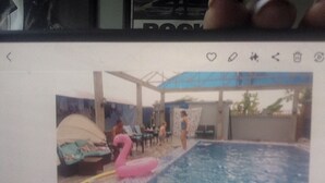 Ein Schwimmbecken mit einem rosa Flamingo-Schwimmpflege und einem Zelt.