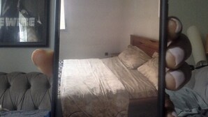 Ein Schlafzimmer mit einem Bett, einer Kopfteil und einem Bild an der Wand.