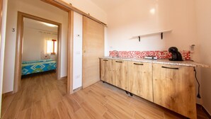 Une cuisine de taille réduite, avec des meubles en bois, un plan de travail et un crédence carrelée en rouge et blanc.