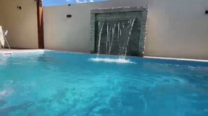 A swimming pool with a water feature.