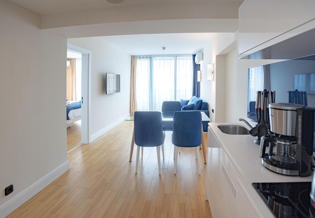 Una cocina moderna con comedor, suelo de madera y vista al salón.